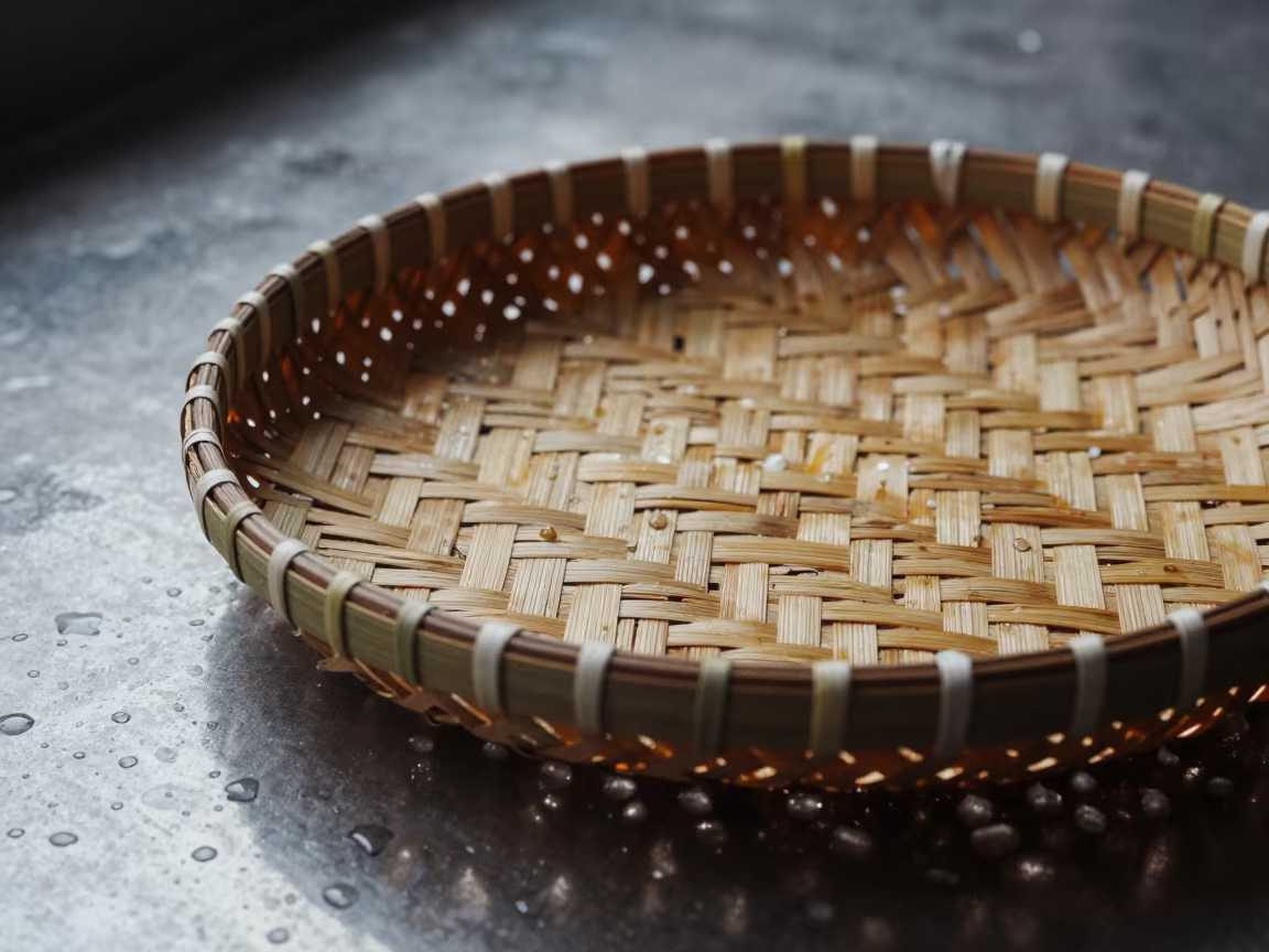 Woven Palm Basket on Rain Beaded Metal in across a rain-beaded metal surface in Bang Rak, Bangkok
