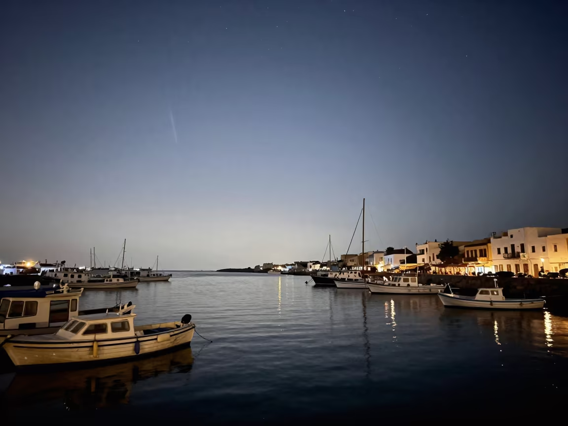 Zodiacal Light Over Tunisian Harbor at Dawn in beside a lantern-dotted harbor in Tunisia